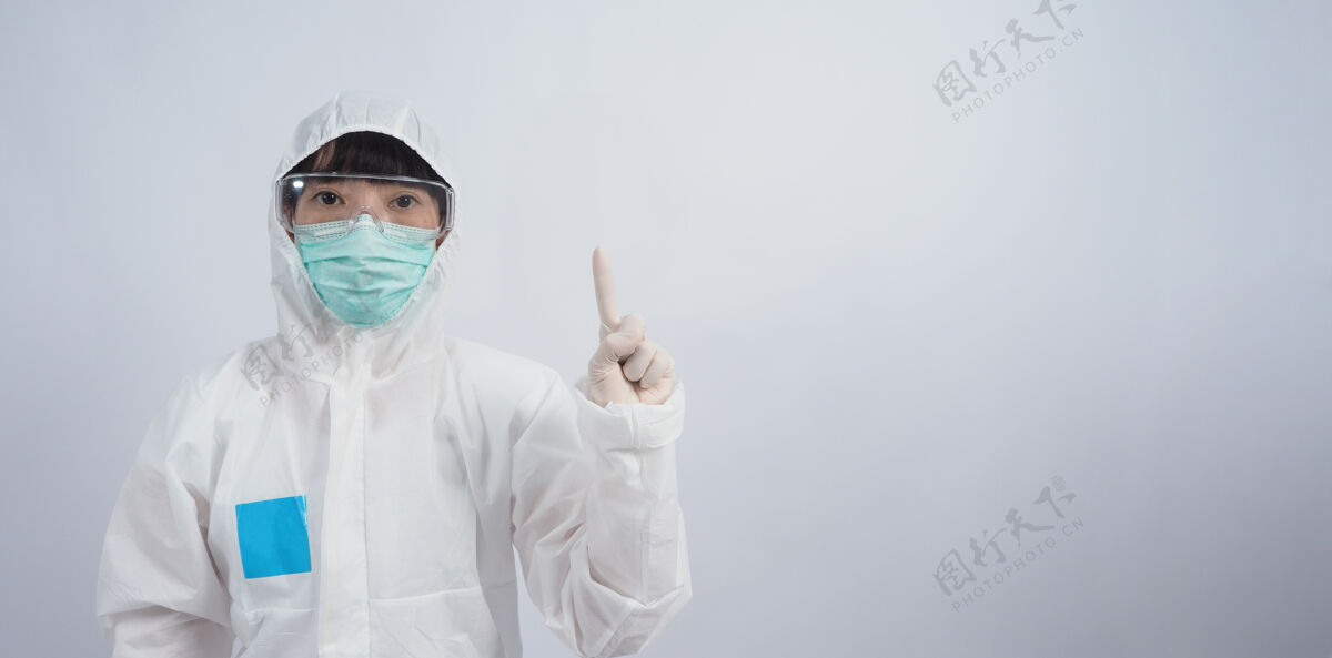 个人防护装备医生手势穿着ppe套装或个人防护装备的亚洲女医生手势和指点外白医用橡胶手套 护目镜眼镜和绿色n95口罩保护大流行的冠状病毒手眼镜病人