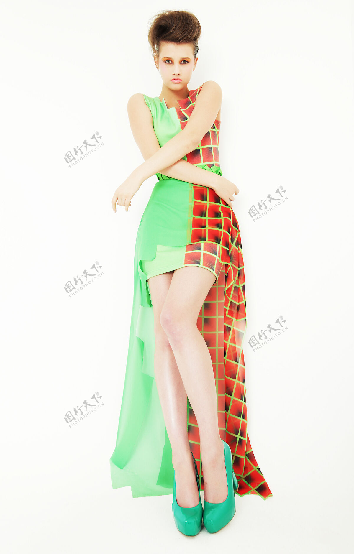 美丽穿着绿色连衣裙的年轻女模特摆姿势脸蛋五颜六色表情
