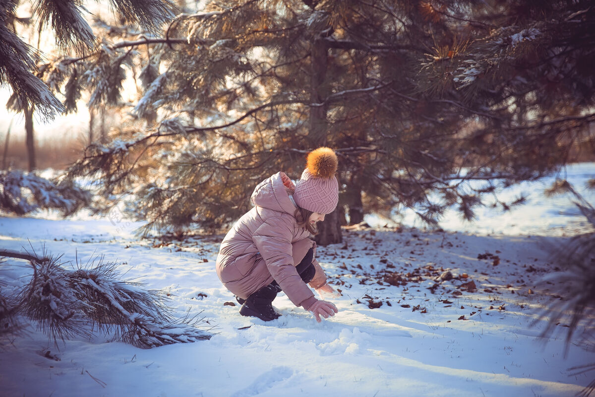下雪小女孩在阳光明媚的冬日里玩得很开心外套享受小