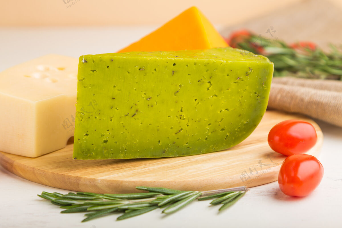 小吃绿色罗勒奶酪和各种奶酪与迷迭香和西红柿在木板上的白色木质表面布里套装烹饪