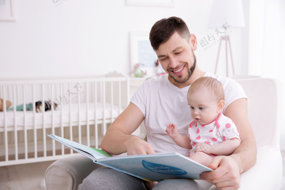 爸爸爸爸在家给可爱的小女儿看书父亲托儿小