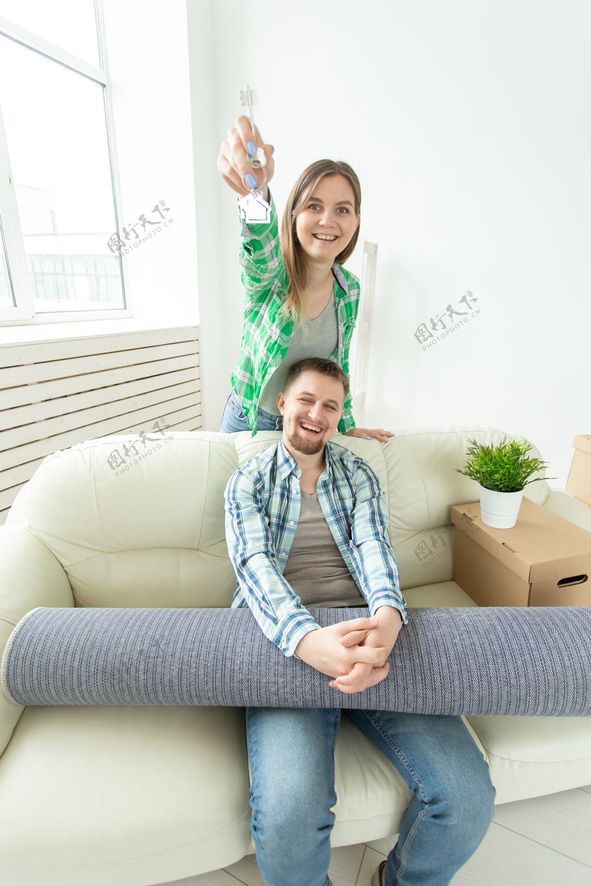 男朋友有趣的年轻女子和她的丈夫手拿着他们新公寓的钥匙坐着房地产丈夫肖像