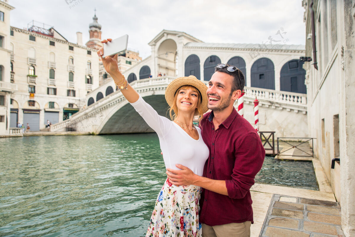 访问年轻夫妇在威尼斯游玩-游客在意大利旅游和观光威尼斯最相关的地标-关于生活方式 旅游 旅游的概念情人影响者手机