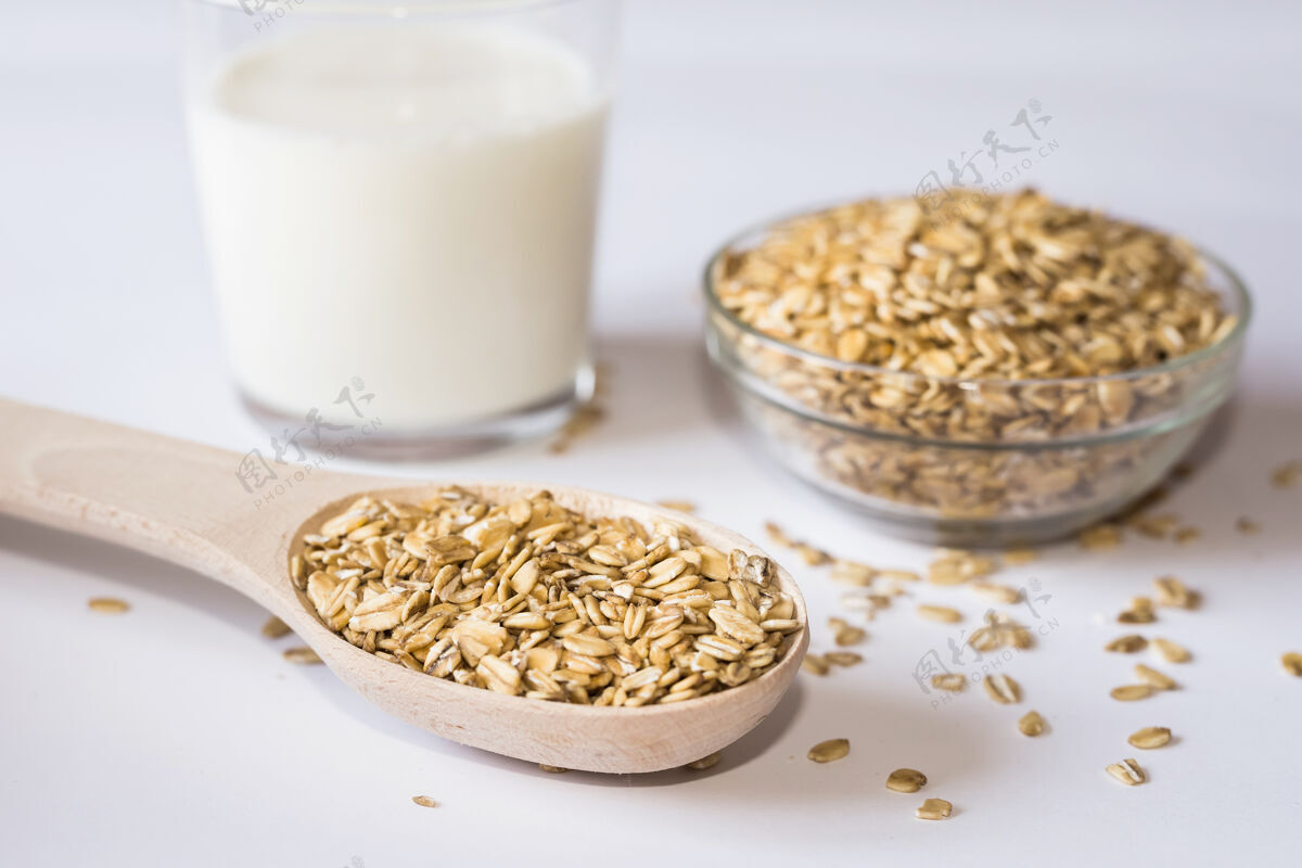 自然燕麦片和一杯牛奶放在白色的表面上素食燕麦谷物