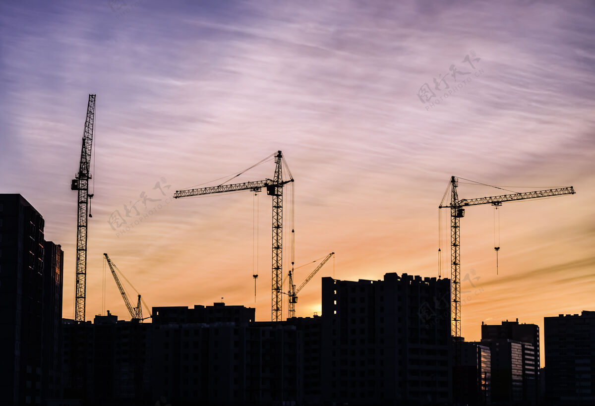 天空建筑起重机和建筑物在夕阳的映衬下建筑起重机形状地产