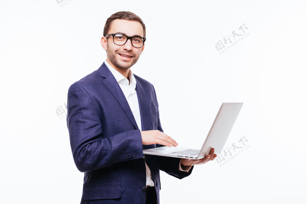 人侧视图迷人的年轻商人在古典西装使用笔记本电脑 站在白墙头发成人员工
