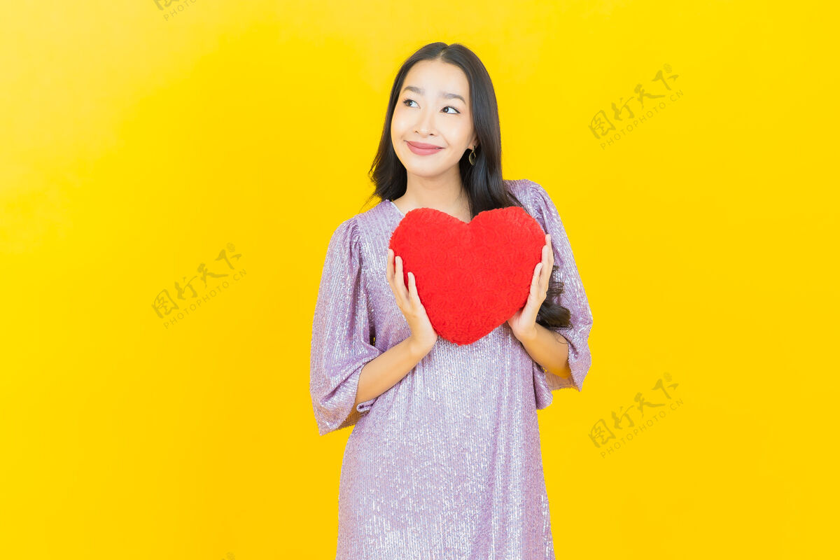 魅力年轻的亚洲女人用心枕举行年轻浪漫