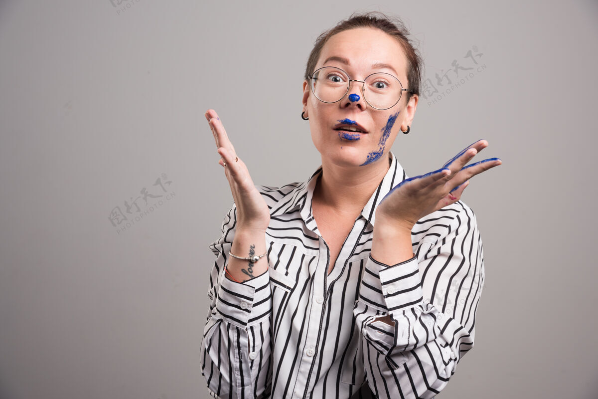 颜色一个女人在灰色的土地上展示她的手女性眼镜女人