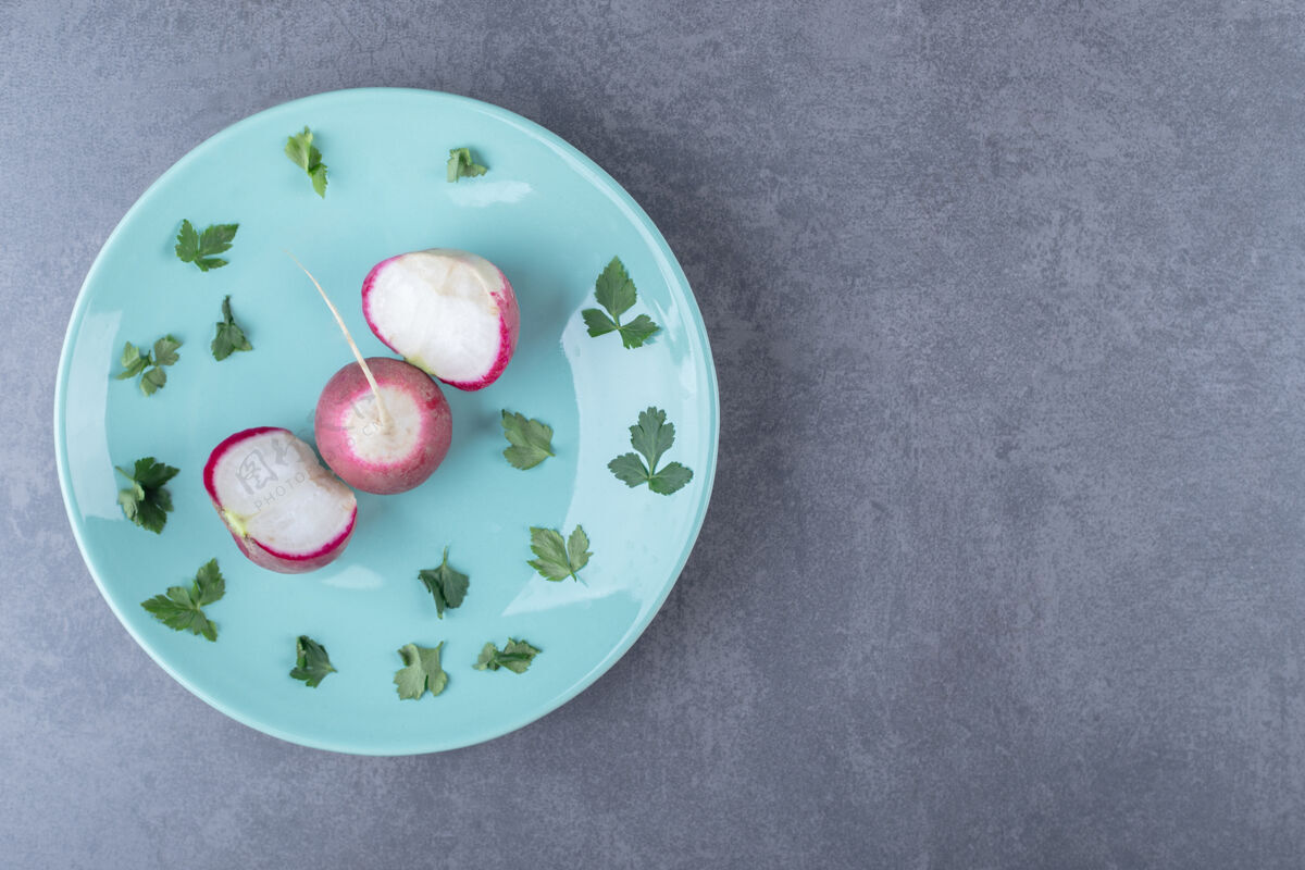 农业萝卜和绿叶放在盘子里 放在大理石表面上美味自然绿色