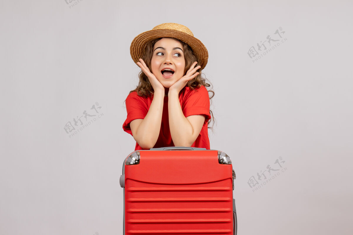 肖像正面图：站着手提箱的年轻女子站着女人度假