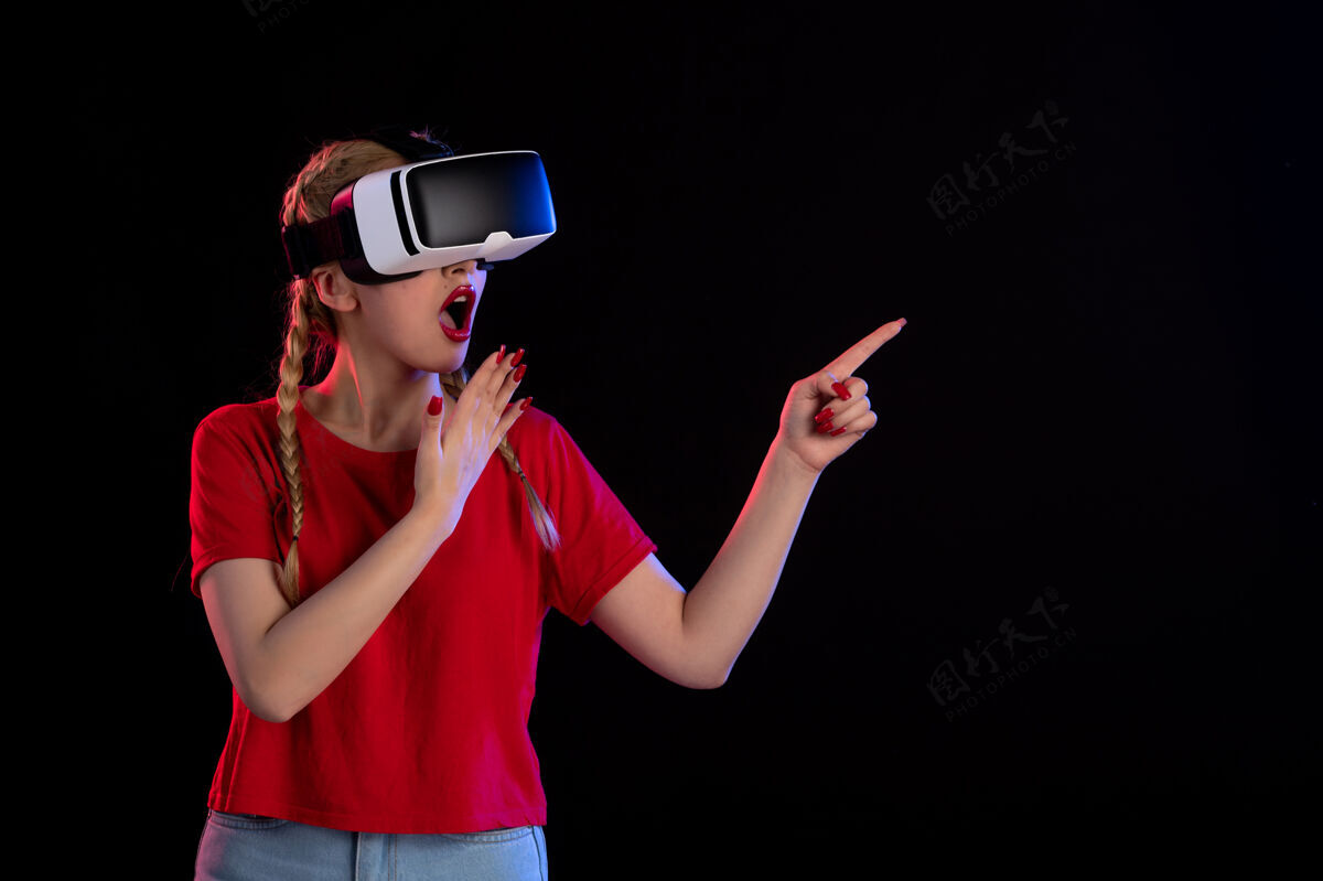 肖像在黑色上玩虚拟现实的漂亮女人的前视图黑暗游戏虚拟现实