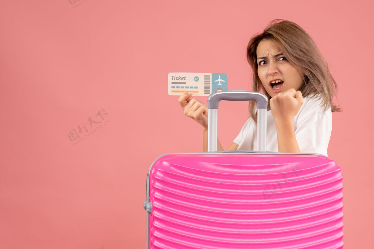 手提箱正面图：带着粉红色手提箱的年轻女孩拿着票人旅游可爱