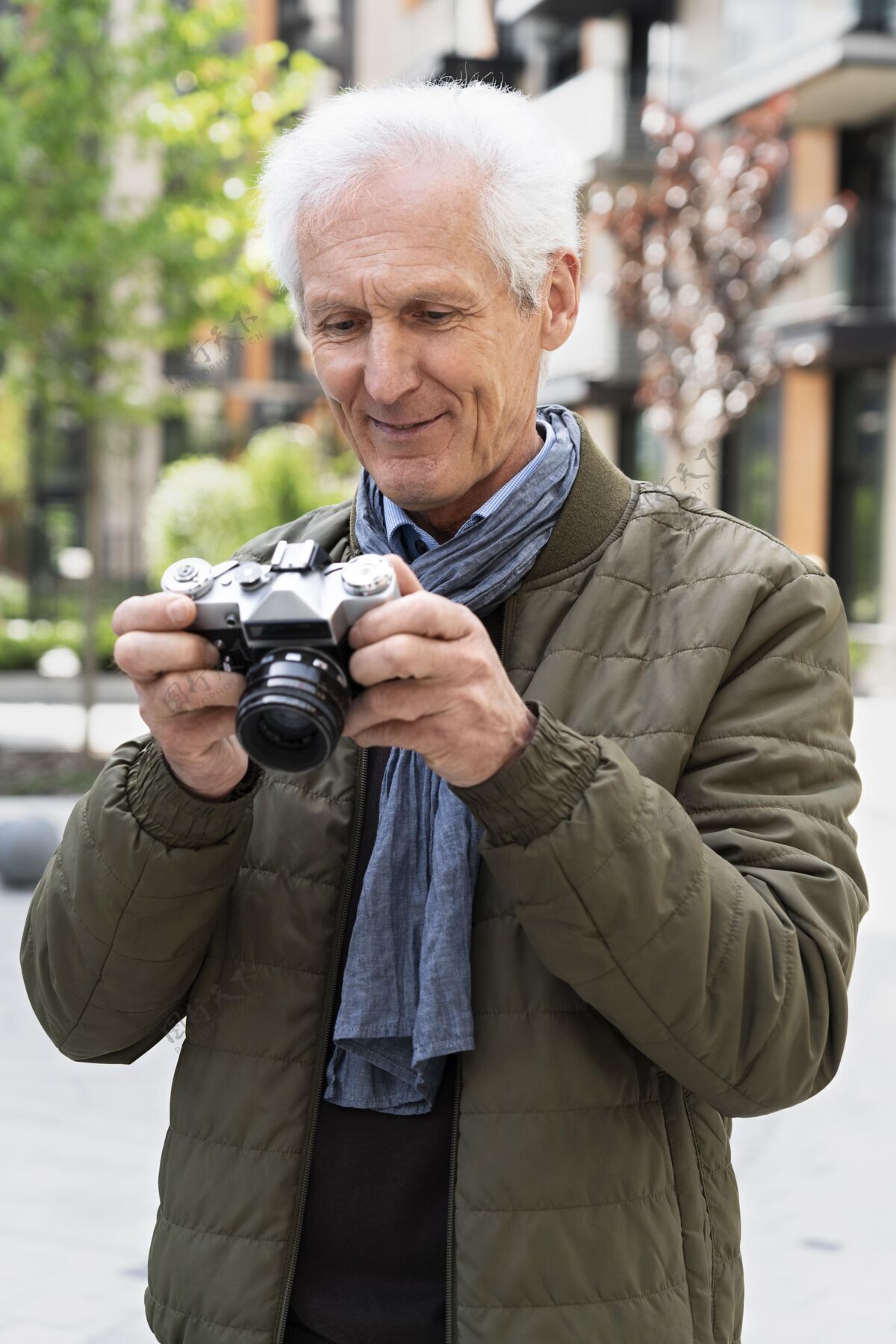 户外时尚的老男人在城市里用相机拍照城市城市老年人