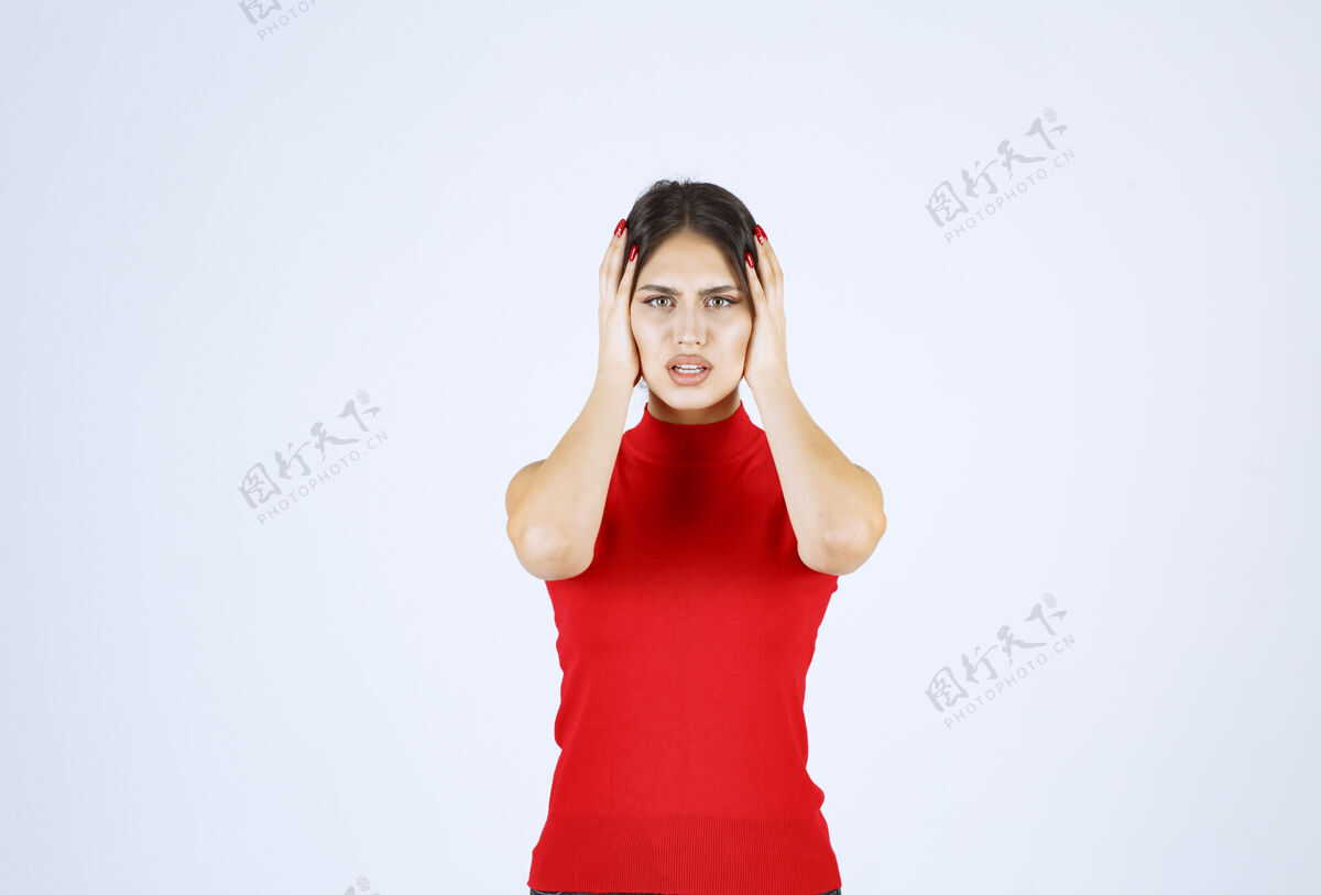 疲倦穿红衬衫的女孩头痛 双手抱着头装备模特休闲
