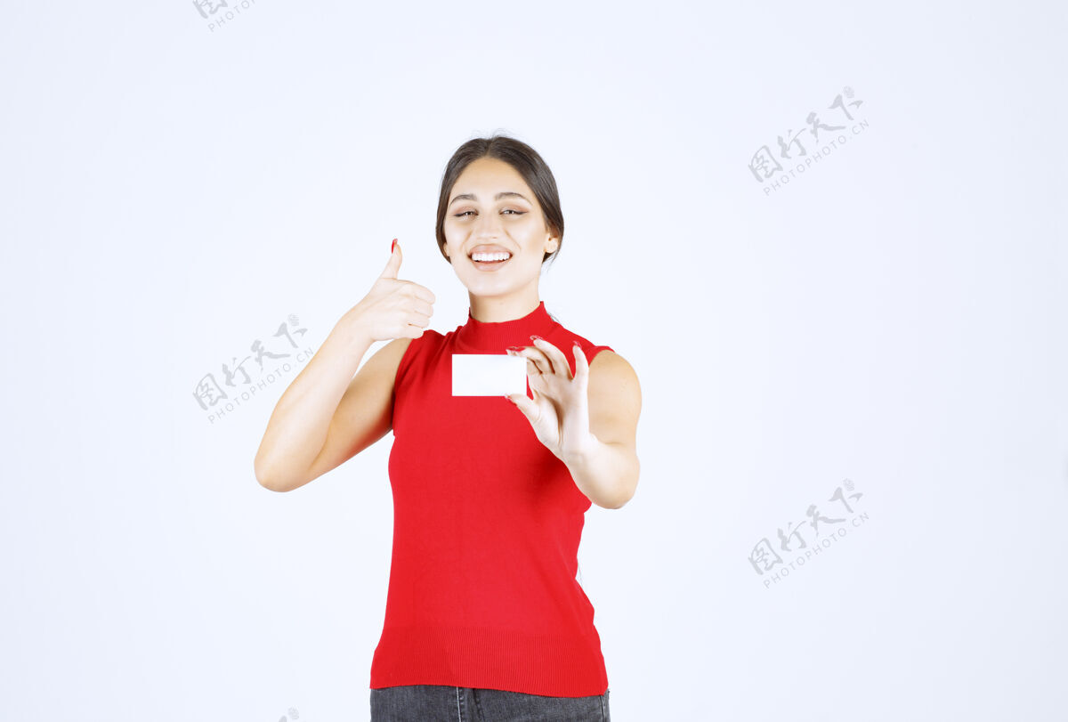 女性穿着红衬衫的女孩拿着名片 看上去很满意休闲工人享受
