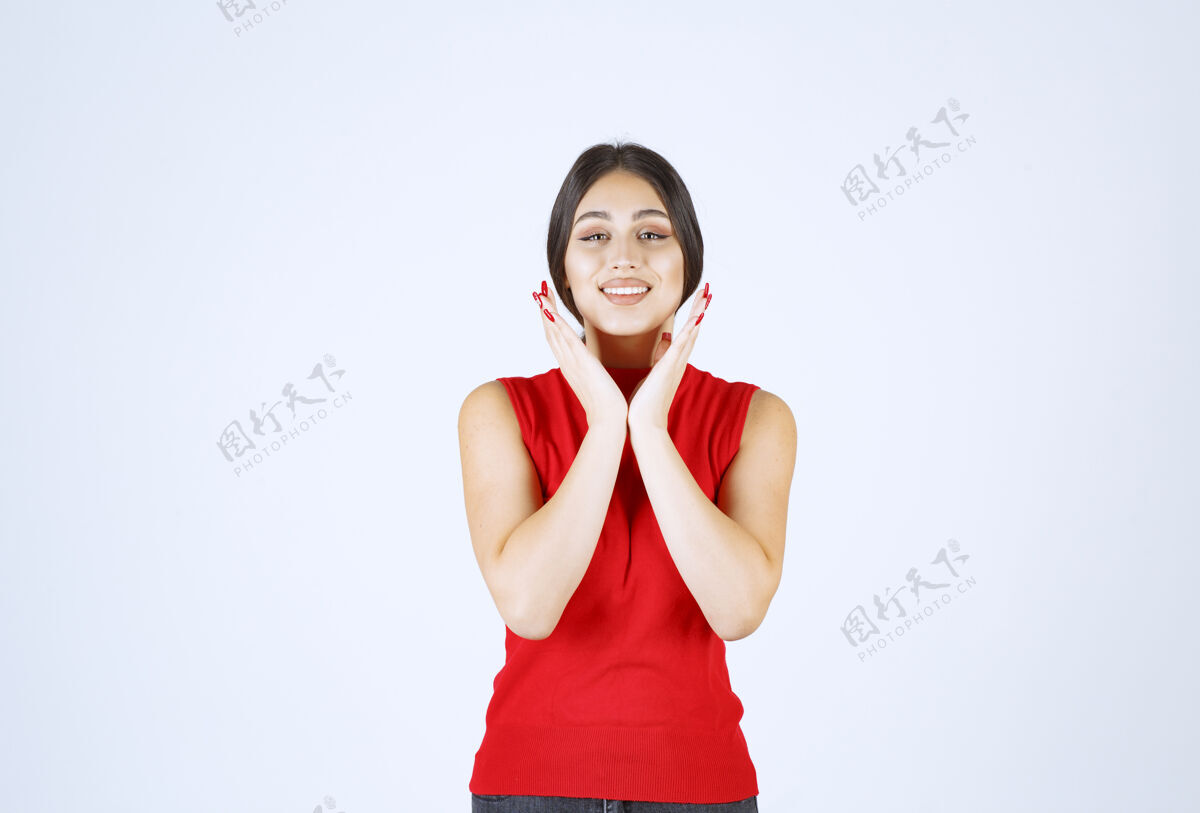 微笑穿红衬衫的女孩摆出中性 积极和吸引人的姿势女人人满意