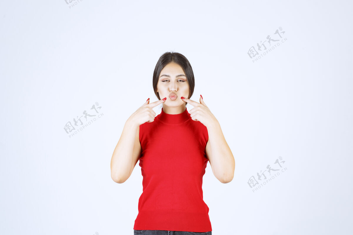 人类穿红衬衫的女孩指着自己的嘴 要求安静年轻人雇员沉默