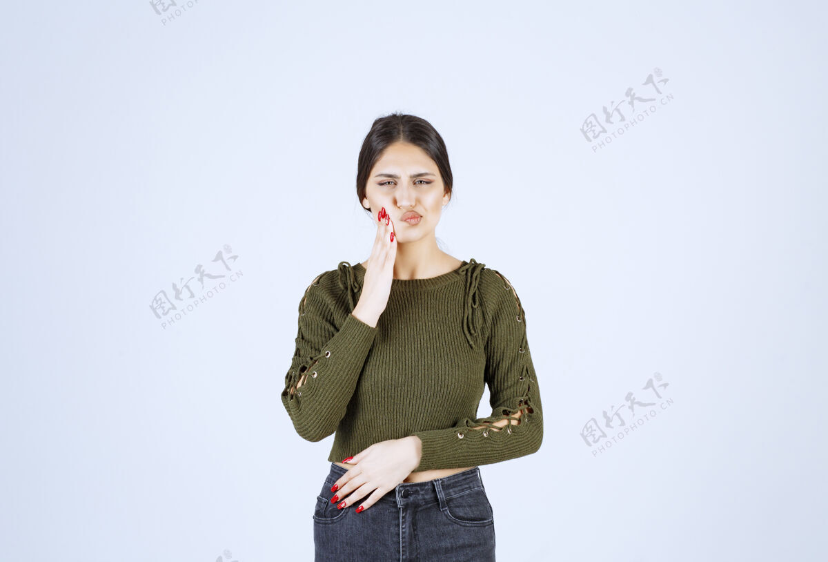 年轻人一位年轻漂亮的女模特站在白墙上摆姿势的画像女人女人人