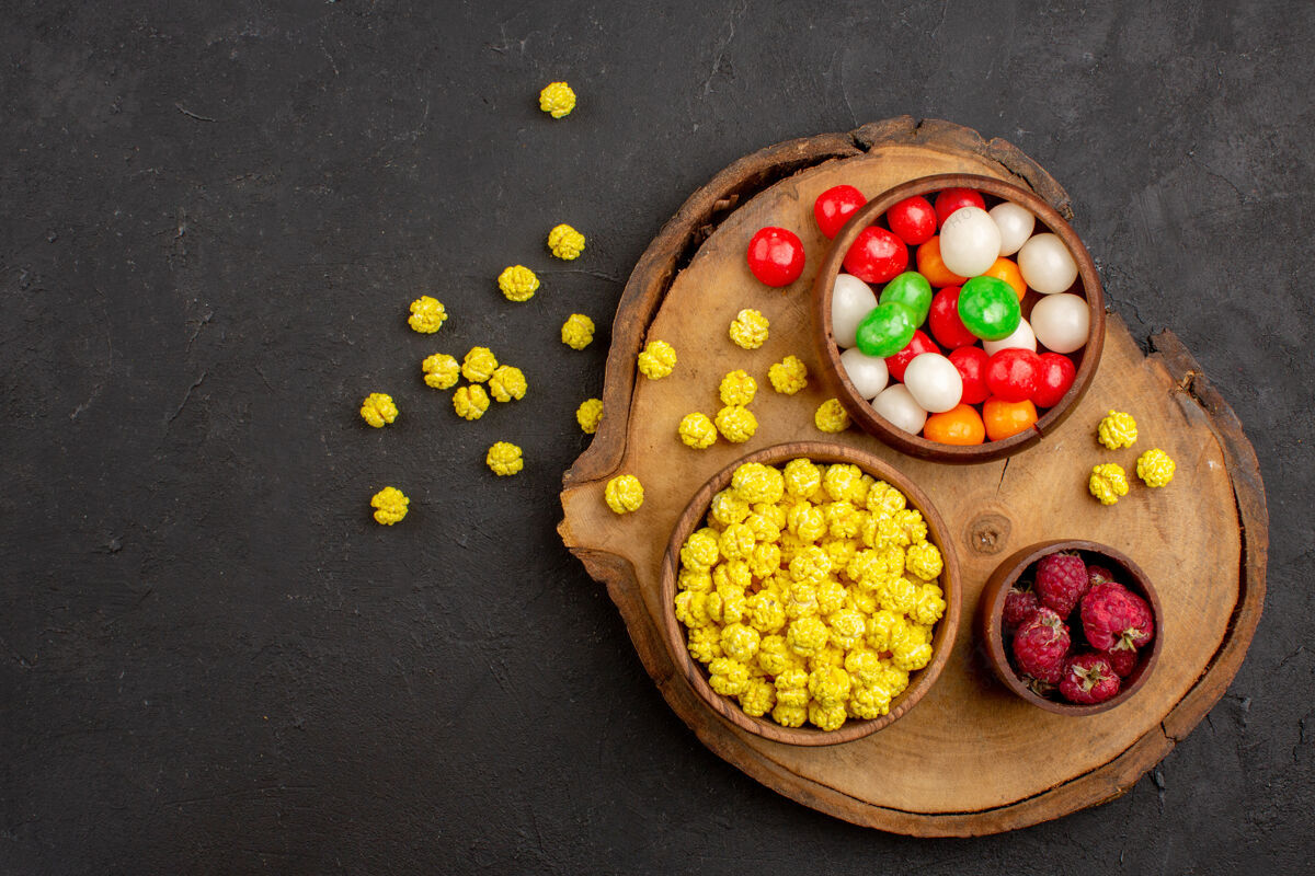 饮食顶视图不同颜色的糖果在一张深色的桌子上糖果颜色彩虹糖茶营养蔬菜糖果