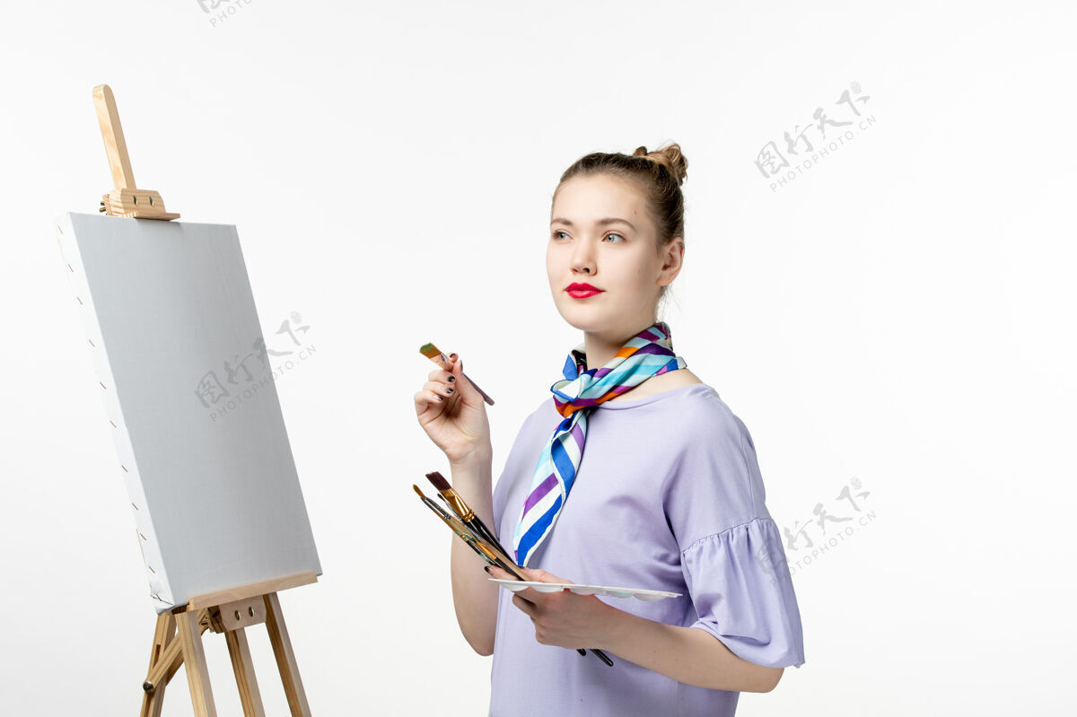 图画前视图女画家准备在白色墙上画艺术画照片画画家画架铅笔医生专业铅笔