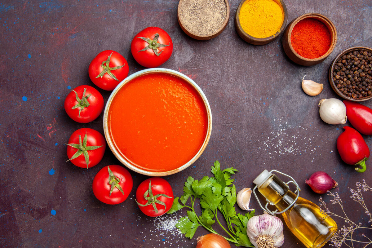 食物俯瞰美味的西红柿汤配上新鲜的西红柿和调味料 背景为深色的西红柿菜晚餐汤酱饭饮食番茄碗