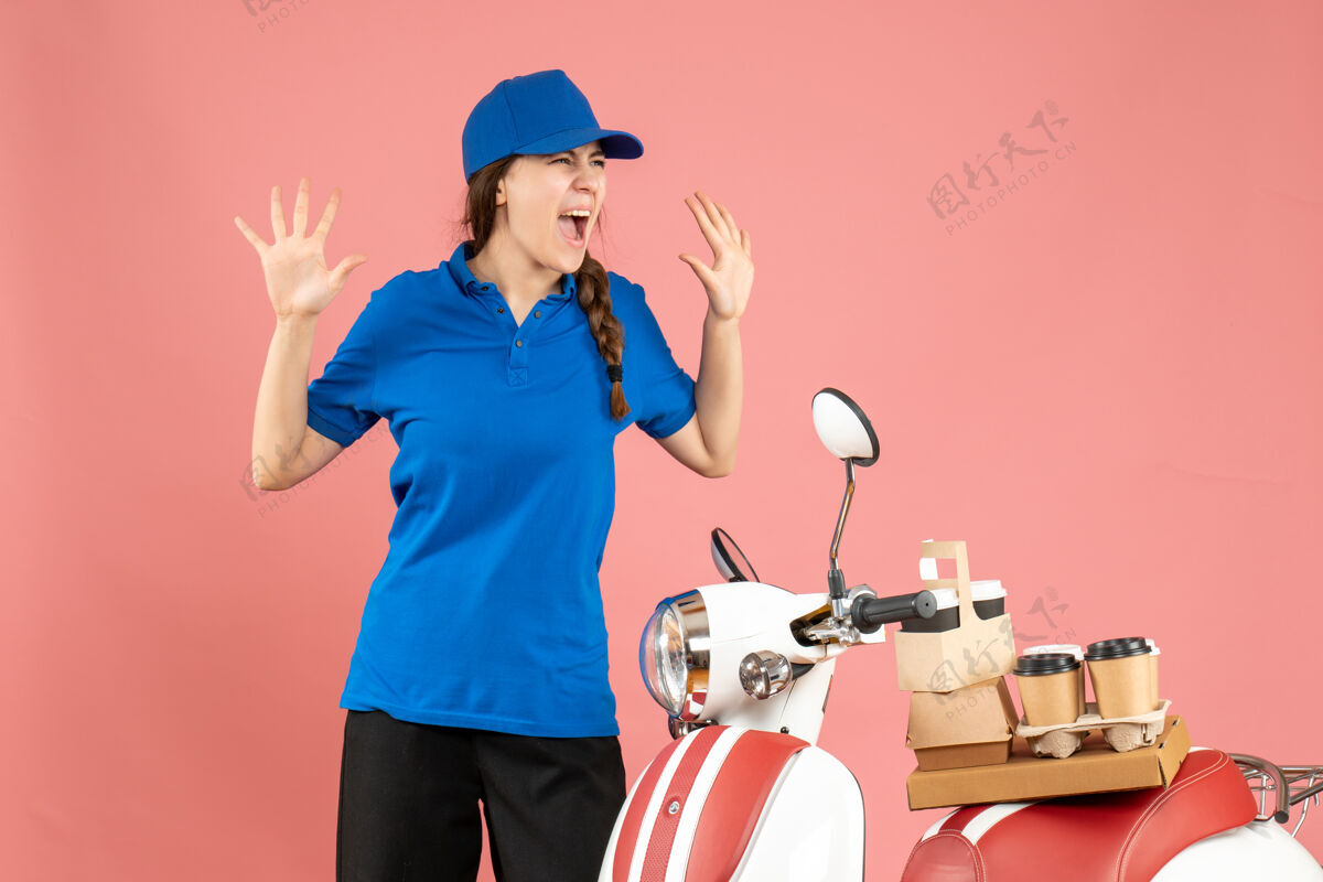 背景俯视图情感信使女士站在旁边的摩托车与咖啡和小蛋糕上的粉彩桃色背景微笑医生蛋糕