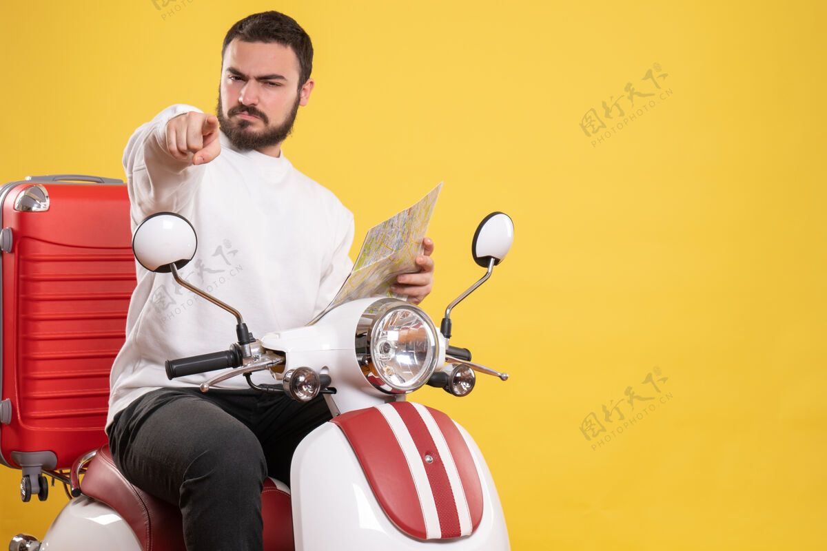 自行车顶视图混乱的家伙坐在摩托车上 手提箱上拿着地图 在孤立的黄色背景上指向前方坐着黄色拿着