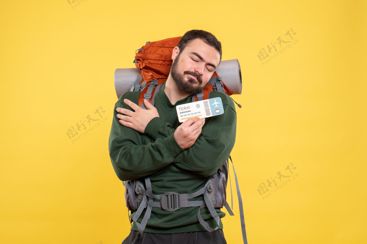 人物年轻的梦幻旅行小伙背着背包 在黄色背景下展示车票扩音器年轻人背景