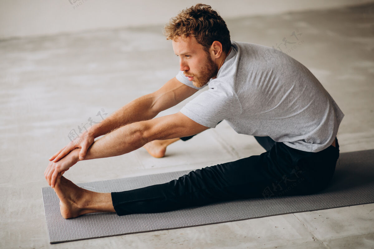 身体男人在家里的垫子上练习瑜伽室内运动员强壮