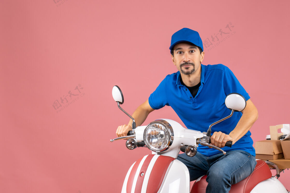 前面前视图的快乐信使家伙戴着帽子坐在粉彩桃背景踏板车粉彩运动员人