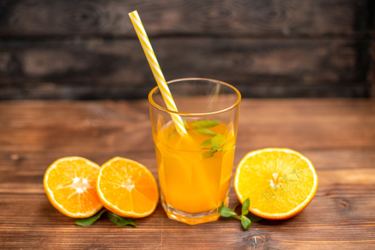 果汁上图：木桌上盛着新鲜橙汁的玻璃杯里放着薄荷和橙汁柑橘木材健康