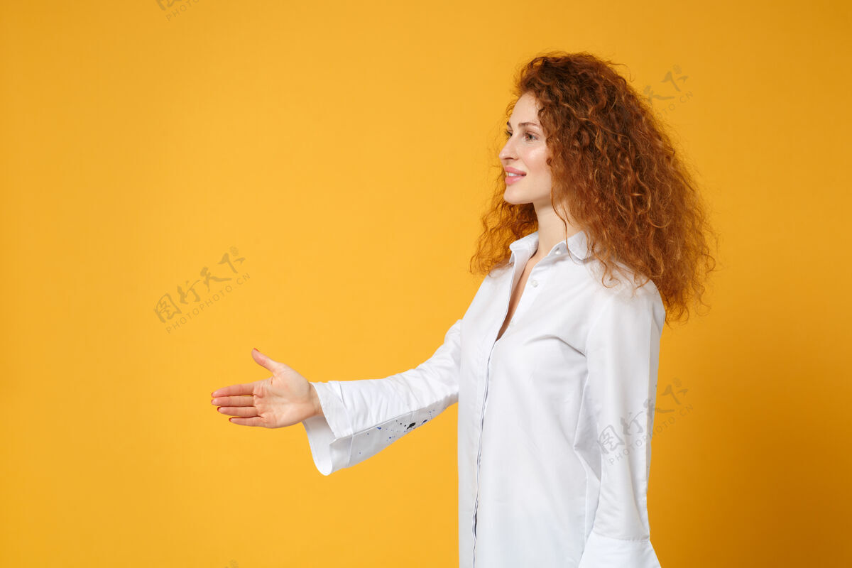 人物侧视图的年轻红发女子女孩在休闲白衬衫摆出孤立的黄橙色墙上橙色青少年时尚