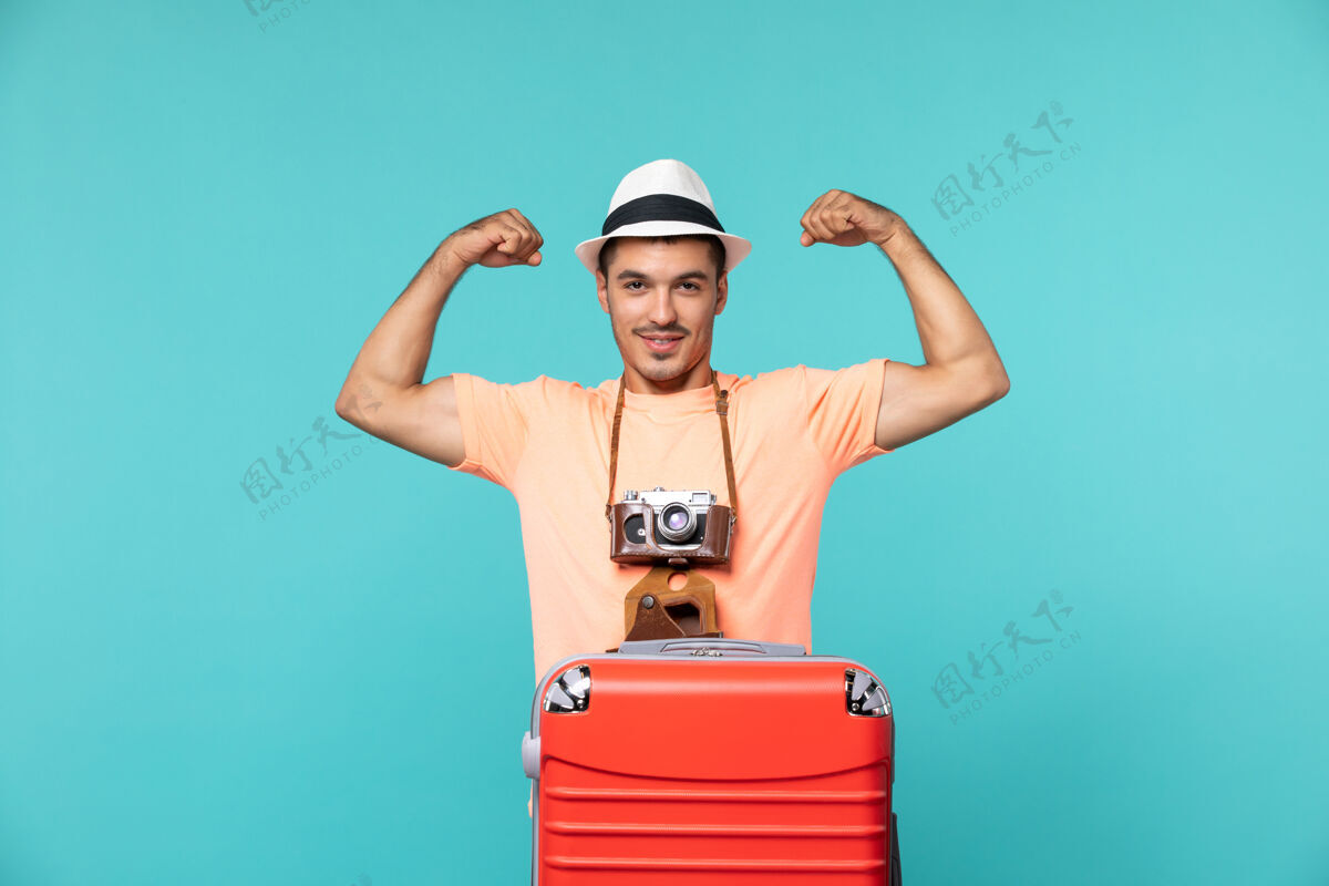 成人带着红色手提箱和蓝色相机的度假男人蓝色旅行包