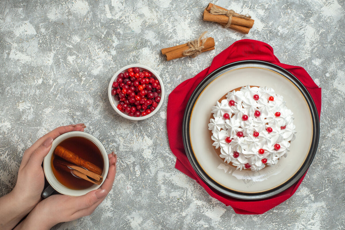 背景俯瞰美味的奶油蛋糕装饰着红色毛巾上的水果水果举行奶油蛋糕