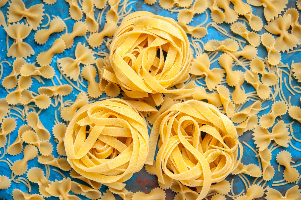 食物在蓝色背景上 意大利面排成一排 晚餐准备的特写镜头玫瑰晚餐意大利面