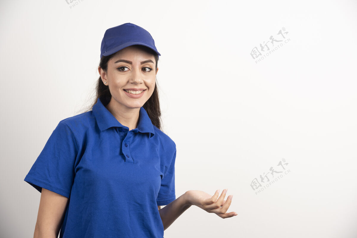站立穿着蓝色制服的漂亮女人用手触摸她的脸高质量的照片服务工人女性