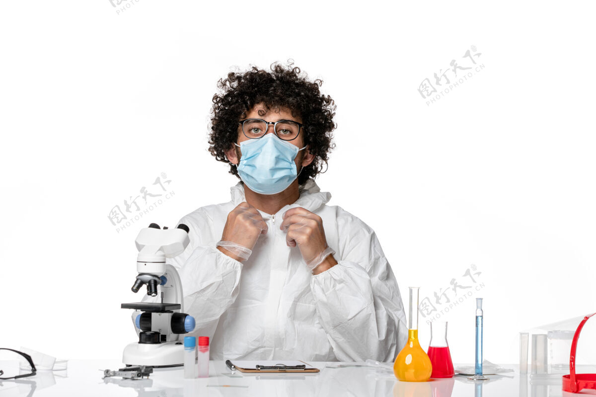 使用男医生穿着防护服 戴着口罩 用显微镜对着白色视图医生男医生