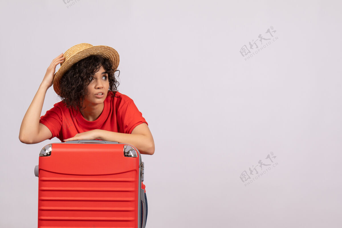 成人正面图年轻女性带着红包准备乘坐白色背景的阳光色航程休息旅游航班度假飞机休闲旅行飞行