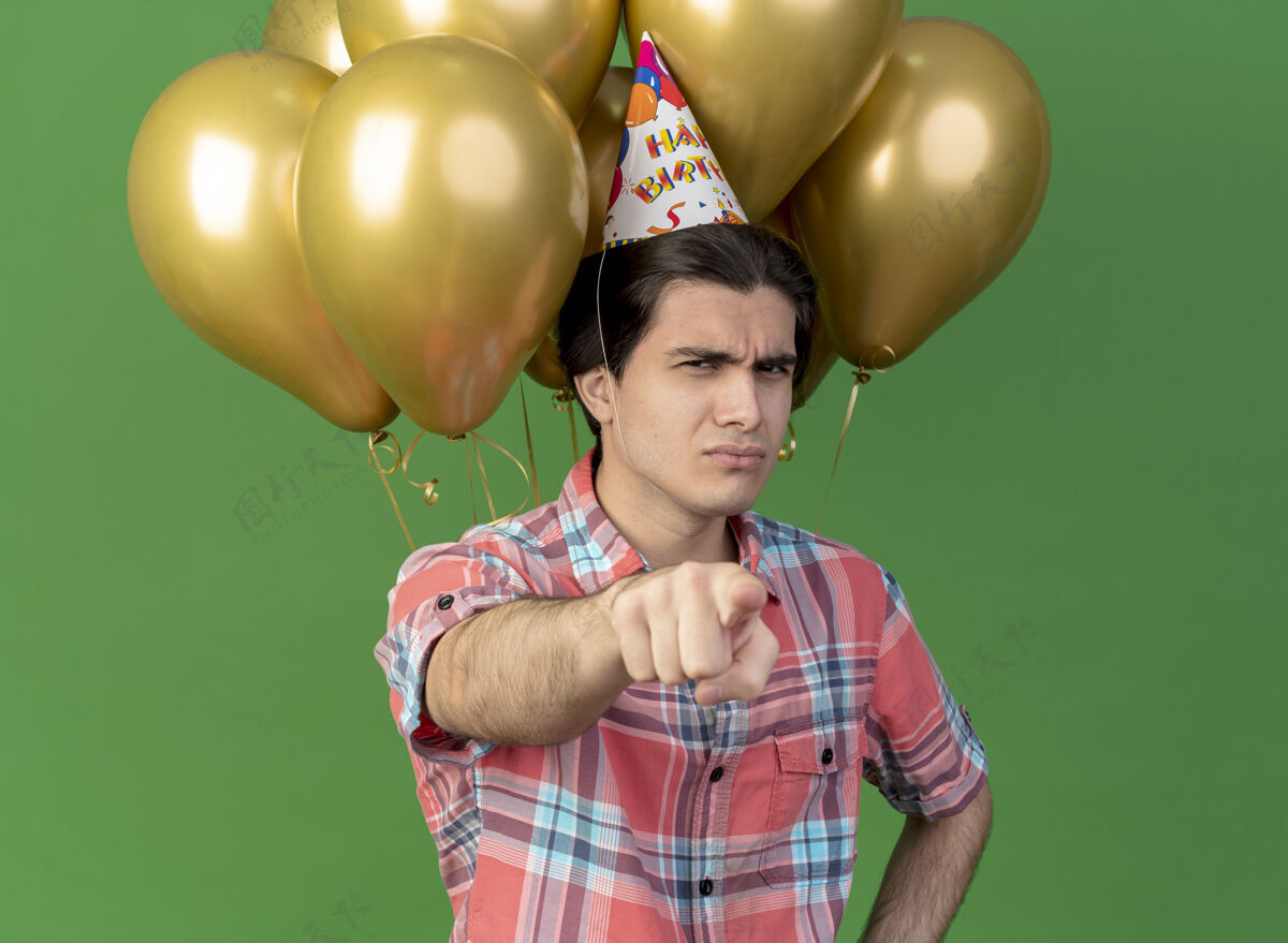 帅哥戴着生日帽的白种人帅哥站在氦气球前指着摄像机气球穿前面