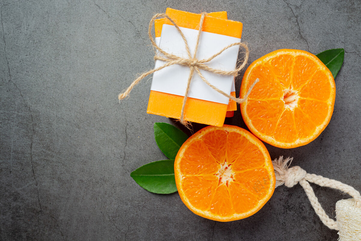 皮肤护理橙色肥皂与新鲜的橙色在黑暗的背景肥皂产品治疗