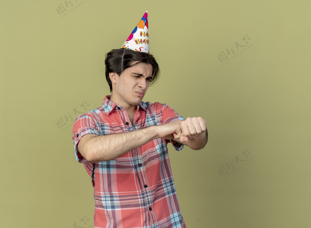 复制恼怒的白人帅哥戴着生日帽握着手看穿举行绿色