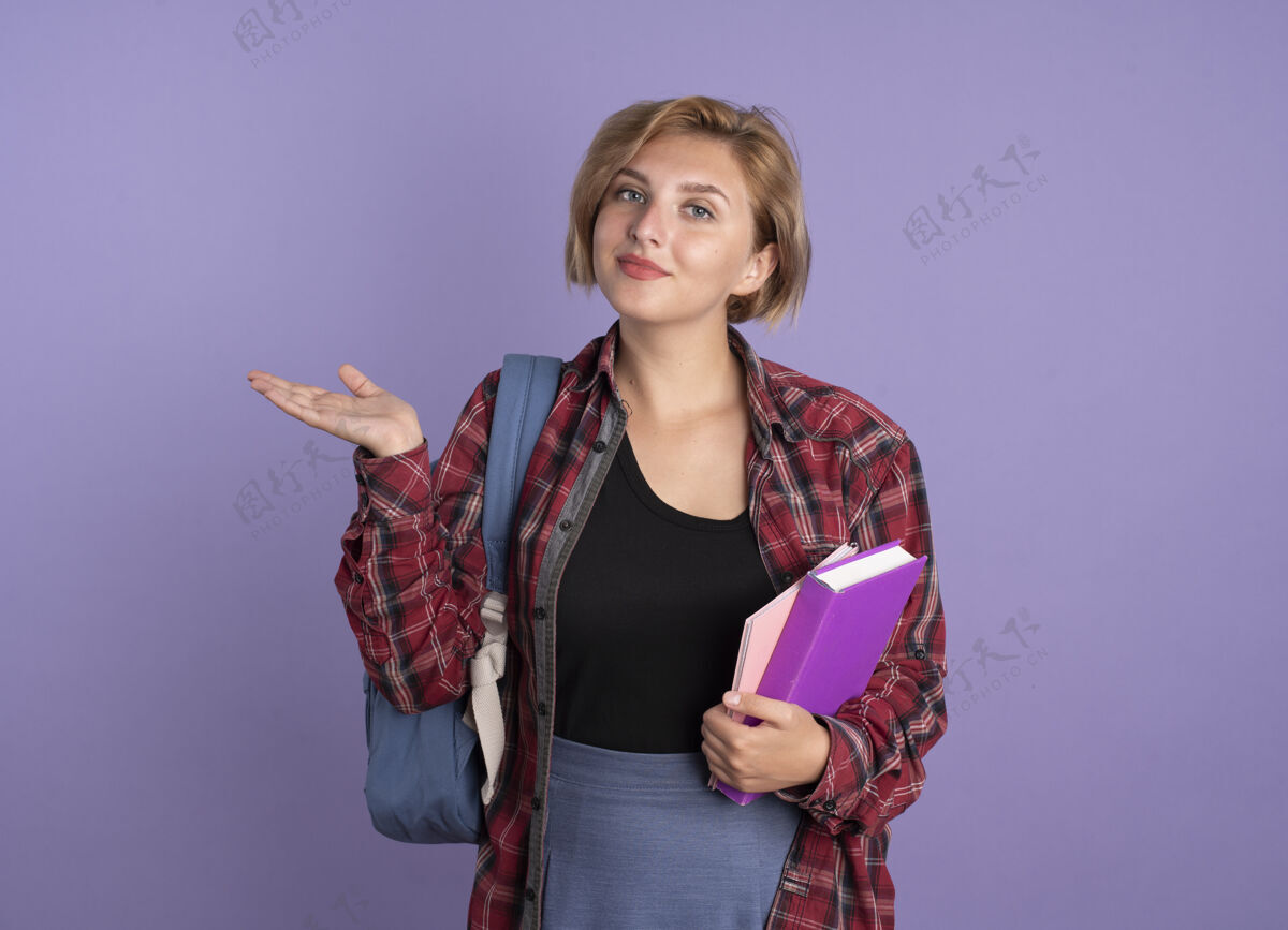 斯拉夫很高兴年轻的斯拉夫女学生背着背包 手张开 手里拿着书和笔记本持有手学生