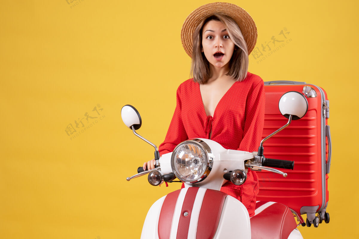 自动机一个穿着轻便摩托车 带着红色手提箱的漂亮女人摩托车成人手提箱