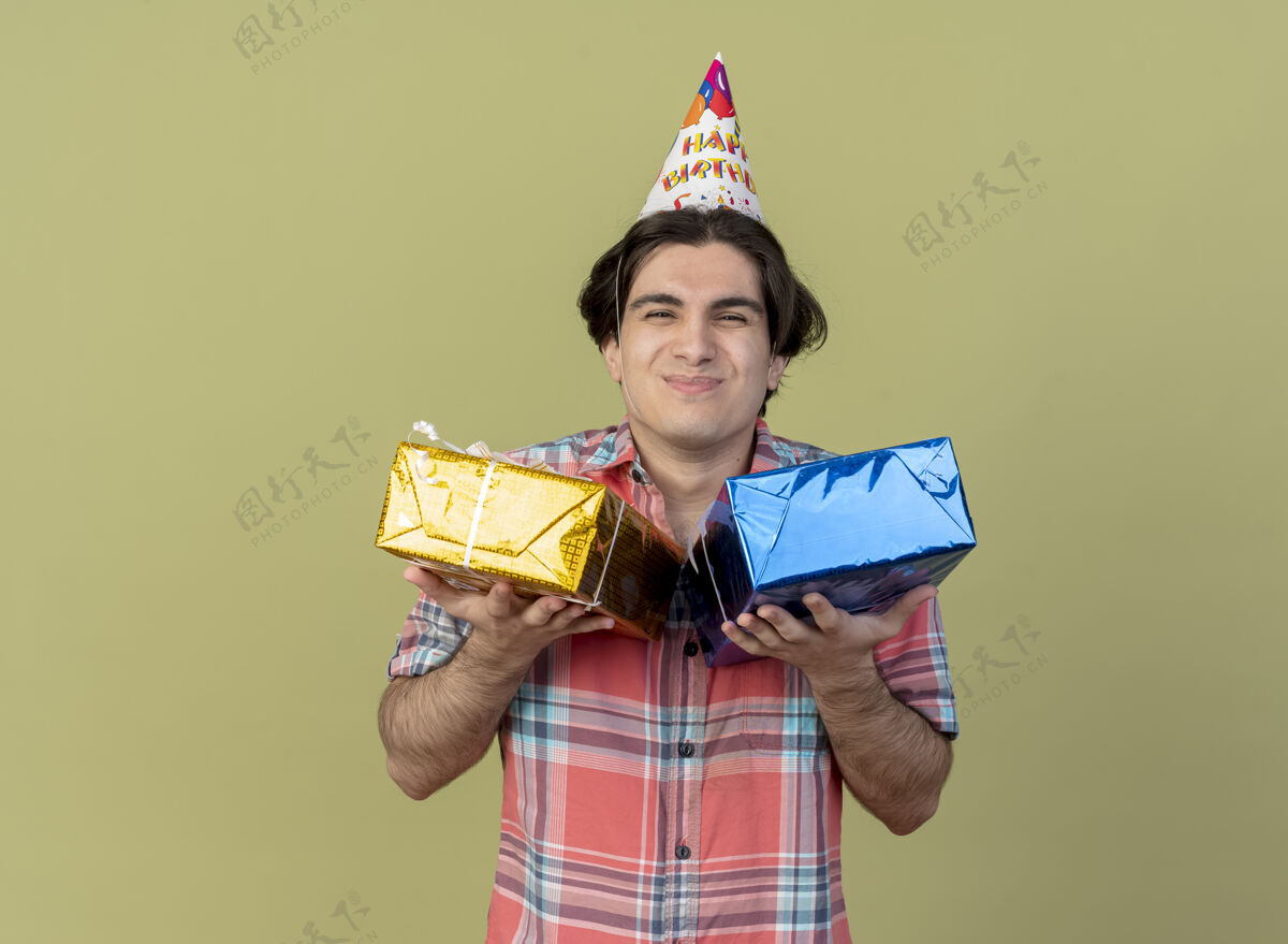 橄榄色高加索帅哥戴着生日帽捧着礼盒高兴极了空格男士生日