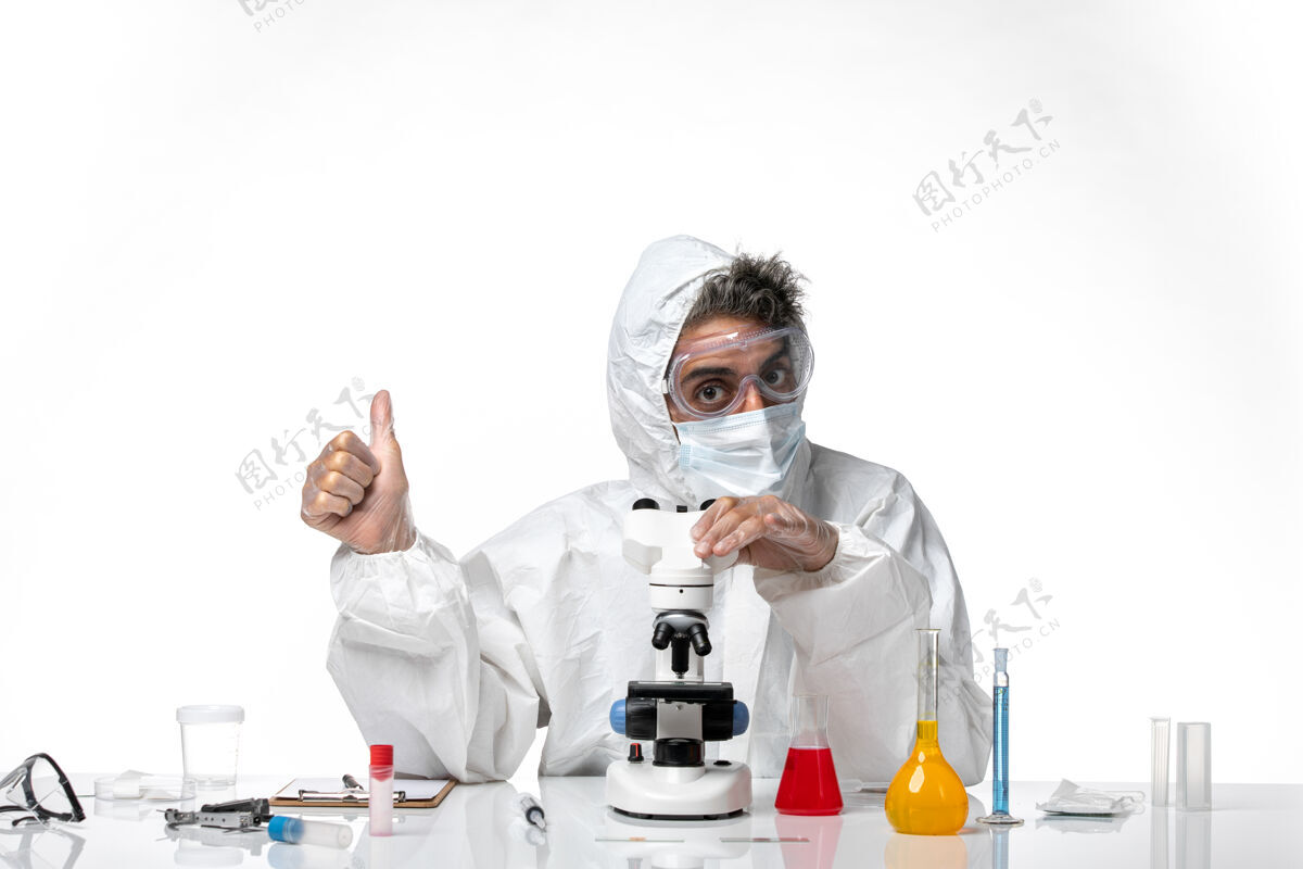 医学男医生穿着防护服 戴着面罩 用显微镜观察浅白色套装显微镜专业