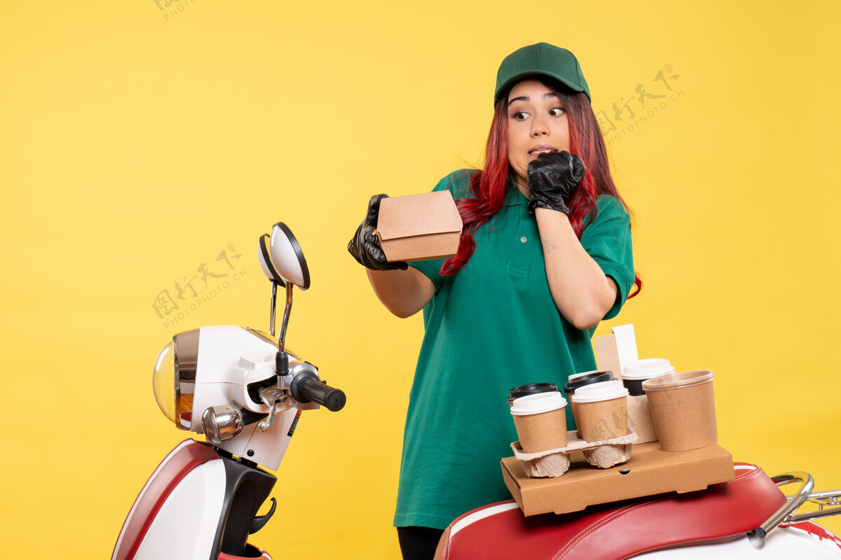 肖像年轻的女快递员用黄色的咖啡送货咖啡人年轻女快递