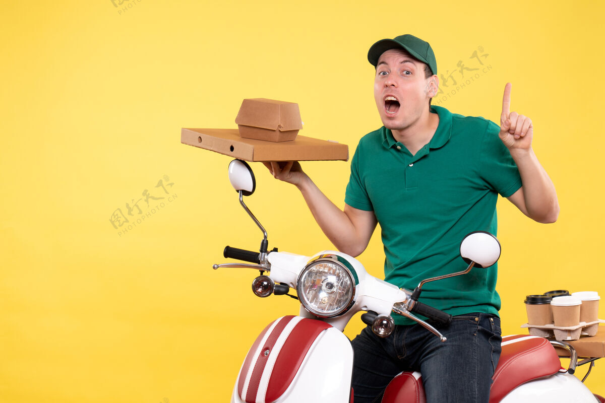 摩托车正面图身着制服的年轻男性快递员手持黄色食品包装工人活动制服