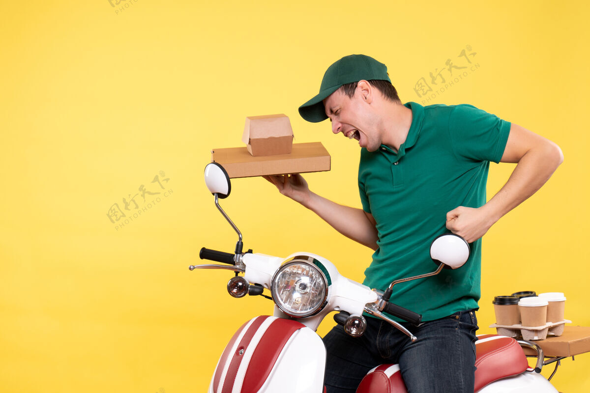 年轻男性信使正面图身着制服的年轻男性快递员手持黄色食品包装服务送货工作