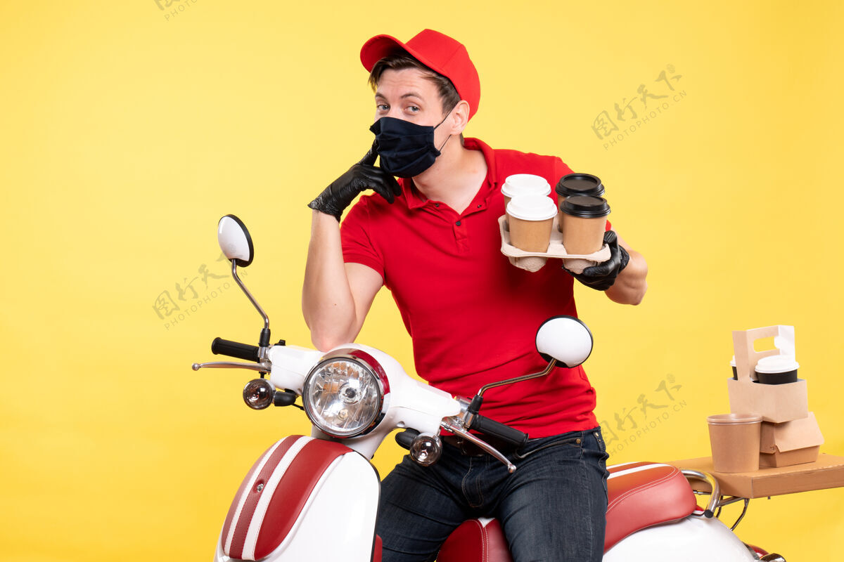 传送带正面图：戴着黄色咖啡面罩骑自行车的男信使送货工作咖啡