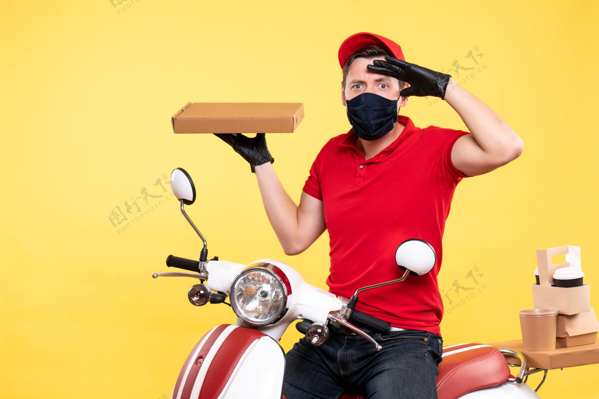 车辆正面图戴着面具的男快递员拿着黄色的食品盒头盔盒子送货
